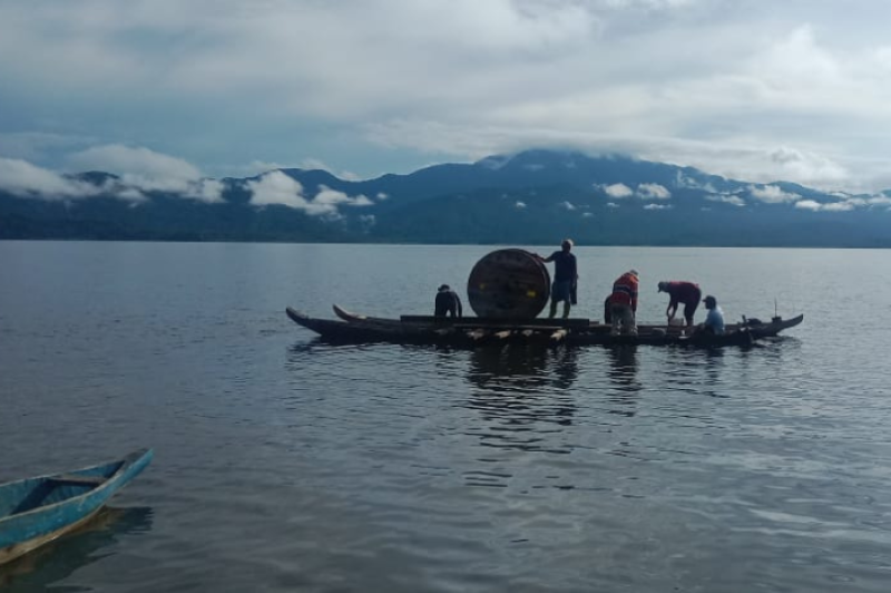 Proses Pengangkutan material untuk pembangunan jaringan listrik di Desa Olu dilakukan menggunakan kapal kayu tradisional melintasi danau. Keterbatasan sarana pengangkutan material, tidak menghentikan upaya PLN untuk membangun infrastruktur kelistrikan di wilayah terpencil guna mendukung pemerataan akses energi bagi masyarakat.