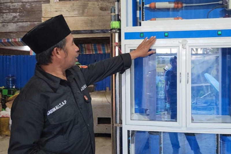 Saidin Ali, warga Desa Olu yang memiliki usaha depot air minum, kini dapat mengoperasikan seluruh mesin produksinya secara bersamaan sejak listrik PLN hadir 24 jam penuh. Kehadiran listrik yang andal tak hanya mempermudah operasional usahanya, tetapi juga turut mendorong peningkatan kesejahteraan sosial dan ekonomi masyarakat setempat.