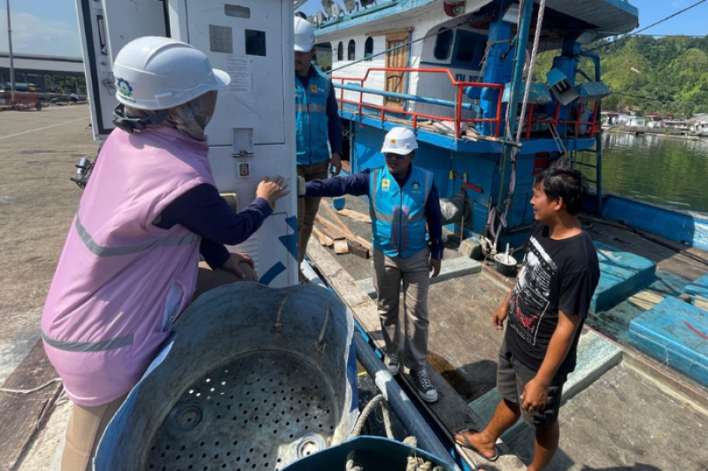 Petugas PLN (kiri) ketika sedang berbincang dengan salah seorang pemilik kapal ikan, Hutagalung (kanan) yang sedang menggunakan ALMA sebagai bagian dari program Electrifying Marine saat kapalnya bersandar di Tempat Pelelangan Ikan (TPI) Kecamatan Sarudik, Kabupaten Tapanuli Tengah, Sumatera Utara.