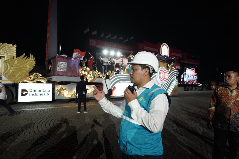Petugas PLN sedang siaga memantau keandalan listrik di tengah kemeriahan parade kendaraan hias pada gelaran Pesta Rakyat dan Karnaval HUT ke-80 RI di kawasan Monas, Jakarta.