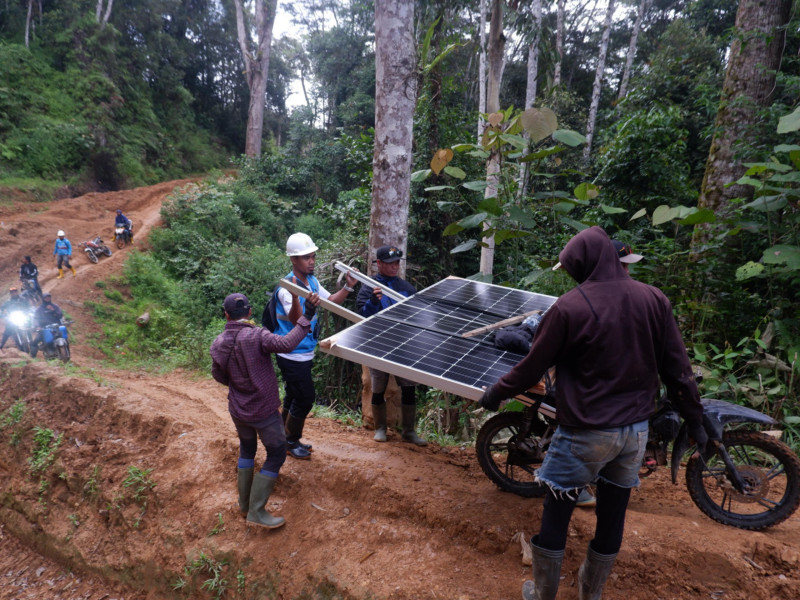 Petugas PLN bersama warga menapaki jalur terjal dengan membawa panel surya berukuran 2,3 x 1,7 meter dan berat 100 kilogram. Hingga kini, 36 unit SuperSUN telah terpasang di sekolah, fasilitas umum, dan rumah ibadah di Kecamatan Seko, Luwu Utara, Sulawesi Selatan.