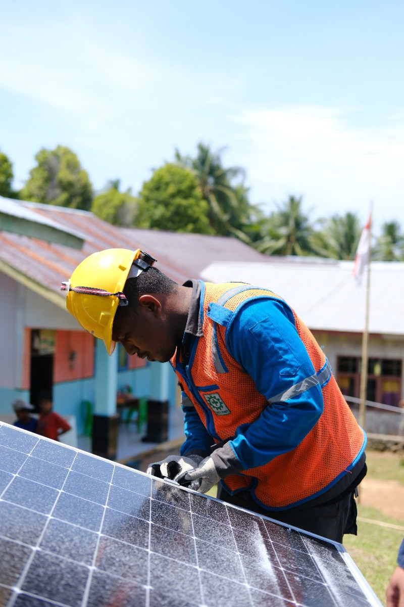 Petugas PLN ketika memasang material panel surya di SMP Negeri Satu Atap Fitako di Pulau Dagasuli, Maluku Utara.