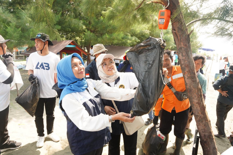 Tampak relawan sedang menimbang sampah yang berhasil dikumpulkan saat kegiatan aksi bersih di Pantai Tirang, Semarang, Selasa (14/10/2025).